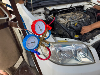 Fototapeta premium Mechanic Checking Automotive AC Pressure Gauges with Tools