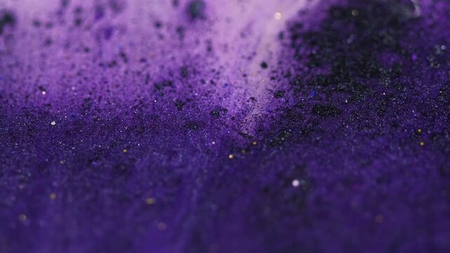 Glitter fluid texture. Sparkling paint. Defocused purple black color shiny sequin particles pigment dust ink spill emulsion gloss flow motion abstract art background.