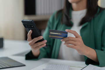 mage of a young Asian businesswoman holding a credit card.