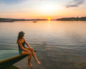 mulher em barco no p&ocirc;r do sol no lago acajutuba, em Iranduba, Amazonas 