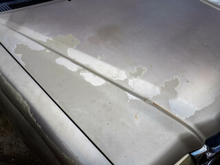 Rust and paint damage on part of the old car body. Peeling off old paint on the car body