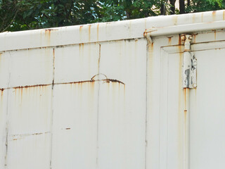 Corroded metal background. The metal wall is painted white with rust spots. Rusted metal background with rust marks, rust stains. Rystycorrosion.