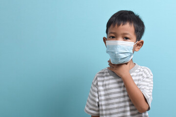 Asian Boy wearing health mask isolated on blue background. Medical and health concept. Human population viruses, infections, flu disease prevention