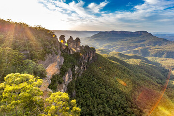 A panoramic view of the Three Sisters rock formation in the Blue Mountains, Australia. The photo was taken from the scenic Echo Point Lookout overlooking the vast mountain landscape.