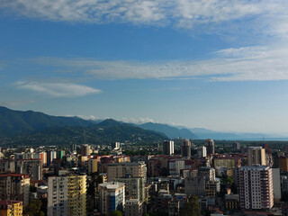 Obraz premium Charming view from the window of the scyscraper on the city, mountains, and the Black sea at sunset