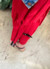 Woman wearing red pants and black dragonfly on her legs. Selective focus.