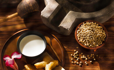 Close up homemade soybean milk in black cup with dry organic soybean seeds  on grunge background  Vintage style. Healthy drink.