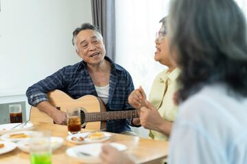 Three Senior friends bonding over music, singing and laughter in party