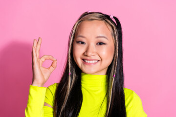 Photo of good mood satisfied girl with dyed hairstyle dressed yellow turtleneck showing okey nice job isolated on pink color background