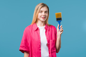 Young woman artist with brush on blue background. Creative person,fantasy,idea