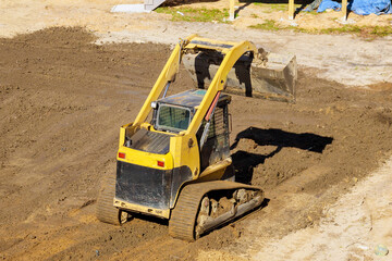 Construction work is being carried out in backyard using tractor to leveling ground