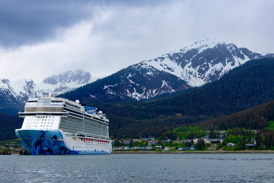 Snow covered peaks behind large cruise ship in harbor at Juneau Alaska 