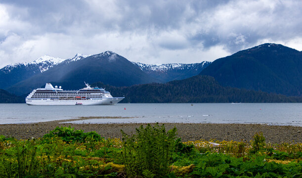 Wide angles shot of a cruise ship in front of mountains on a cloudy day in Alaska 