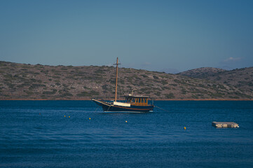 Charter wooden boat in the serene waters of Elounda Gulf, Crete, Greece