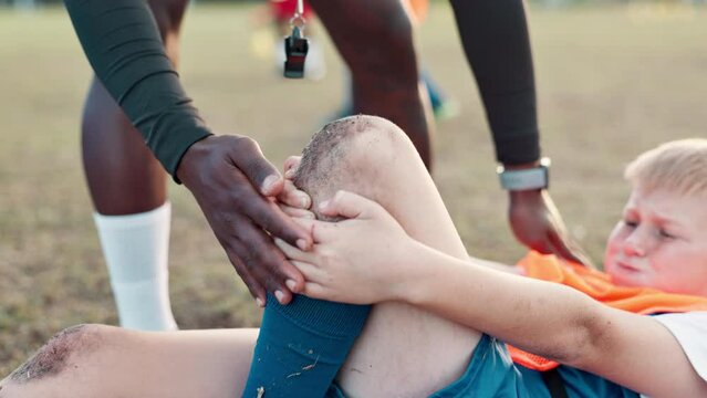 Soccer, player and knee pain for injury, accident and muscle tension during kick in sports competition. Football field, hands and coach with boy for helping, support and patellar tendinitis for kid