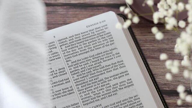Studying Genesis holy bible book, reading Old Testament Scripture with cup of coffee on wooden table. Christian biblical concept. Close-up.