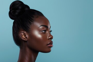 Naklejka premium Beautiful woman, skincare, and cosmetics shine on blue background in studio with tranquil model. Dermatology, makeup, and self-care