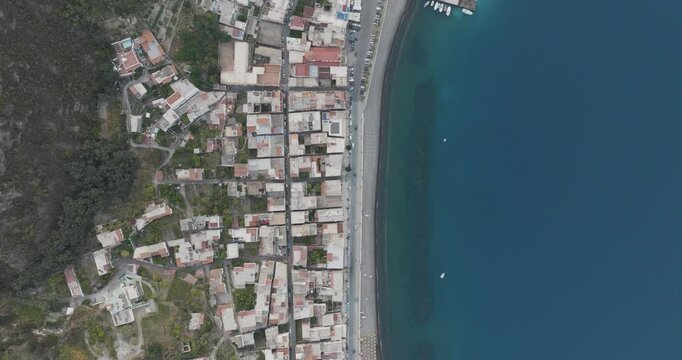 Aerial view of coastal town with buildings, homes, boats, and beach, Lipari, Aeolian Islands, Italy.