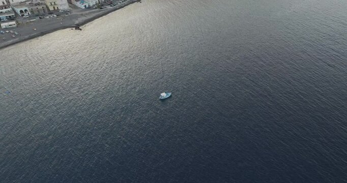 Aerial view of tranquil seaside town with buildings, boat, and shore, Lipari, Aeolian Islands, Italy.