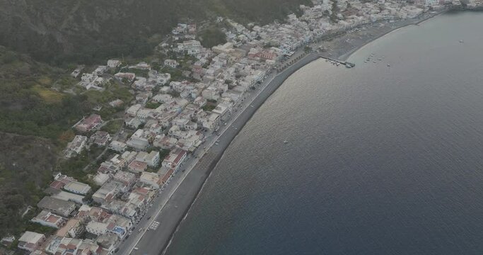 Aerial view of coastal village with mountain backdrop, Lipari, Aeolian Islands, Italy.
