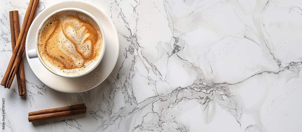 Poster top view of a cup with coffee and cinnamon sticks on a marble surface providing copy space image.
