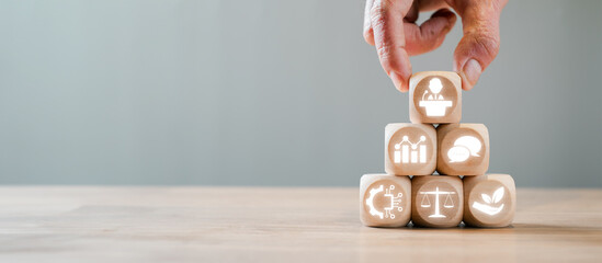 A hand arranging wooden blocks with icons symbolizing political, economic, social, technological,...