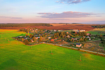 Rural landscape on sunset. Houses in village at green field. Village wooden house in rural. Roofs...