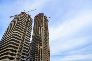 Fototapeta premium Skyscraper Construction. Tower Crane on formworks on construction site. Construction crane on Housing. Construction of Multi Storey Residential Building. Skyscraper built. Tower Cranes on building.