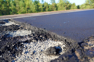 Asphalt road after laying asphalt. New asphalt road renovation. Road construction. Paved sidewalk. Black tarmac pedestrian road, repair. Black tarmac rebuilding. Street Asphalting.