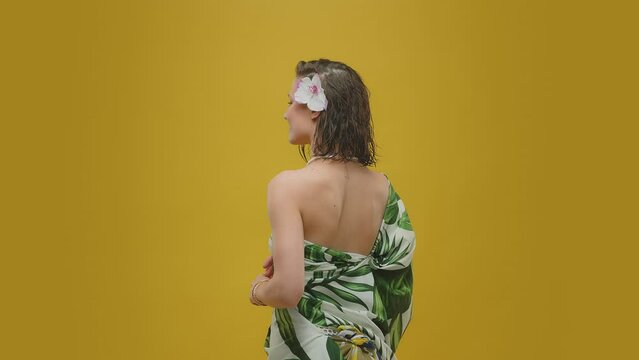 A woman in a pareo on a yellow background