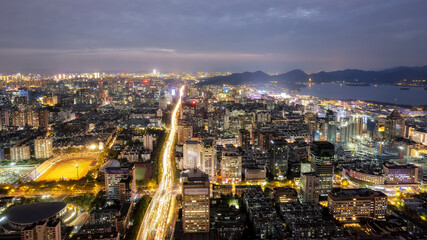 Vibrant Cityscape at Night with Illuminated Roads and Skyline