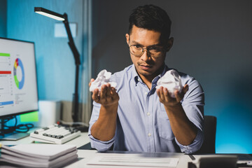 Serious businessman is stressed and busy working overtime in the office.