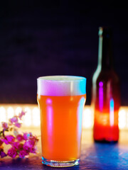 Craft beer glass, India Pale Ale . Open beer bottle, color backlight