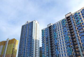 Facade building on blue sky background. Modern building, houses. Colorful buildings with glass windows, balconies. Buildings architecture. Skyline Skyscrapers. Urban Residential building exterior.