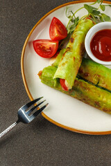 Healthy vegetarian breakfast. Small lavash rolls with spinach, mozzarella and tomatoes with tomato sauce. Dark background. Simple recipe. Menu of cafes, restaurants. Snack for children.
