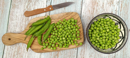 tas de petits pois crus sur une table	