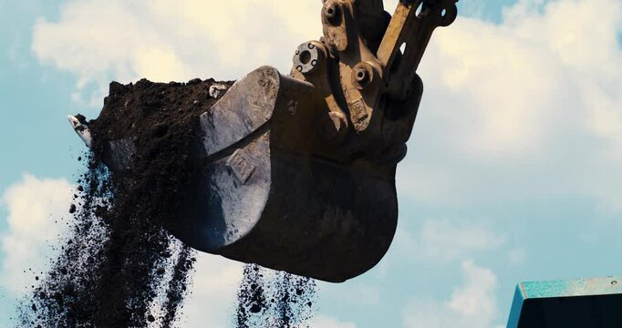 Super slow motion close up of slate concrete debris of demolition of roads and building falling from excavator during quality control and sorting process at landfills plant industrial factory,1000 fps