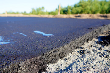 Asphalt road after laying asphalt. New asphalt road renovation. Road construction. Paved sidewalk. Black tarmac pedestrian road, repair. Black tarmac rebuilding. Street Asphalting.