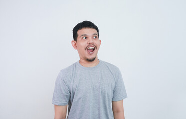 Fototapeta premium Wow and shocked face of funny Asian man isolated on grey background.