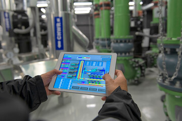 Person using a tablet on chiller water pump for HVAC system on background. person working on a digital tablet on air condition system plant.