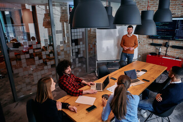 In a corporate setting businessman leads a meeting, passionately presenting a business plan to his attentive team, fostering collaboration and strategic thinking