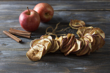 Homemade dried apples with cinnamon, apple chips on a wooden background. Delicious healthy snack