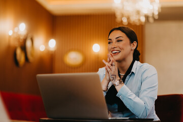 Radiant Latina businesswoman confidently leads business meeting over coffee.