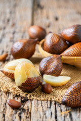 Salak (Salacca zalacca) or Snake fruits on sack and on old wood background,