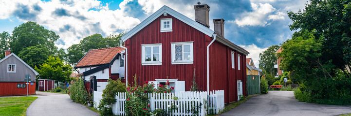 Kalmar a beautiful town in the south of Sweden. Travel touristic Landmark. Traditional little red wooden houses. Beautiful small cozy house with clay tile roof. Plants and roses decorates home entre.  © GenоМ.
