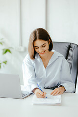 Woman Signing Documents at Office Desk