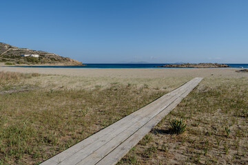 View of a wooden path leading to the beautiful sandy beach of Magganari in Ios Greece