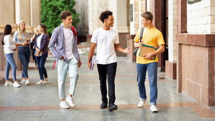 College friends walking during break in campus and chatting outdoors