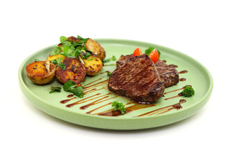 Juicy steaks with potato garnish on a stylish green plate