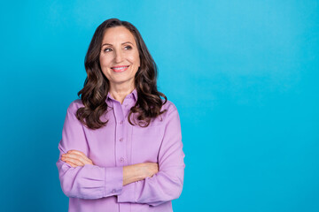 Obraz premium Photo of cheerful pretty lady dressed puple blouse arms folded looking empty space isolated blue color background